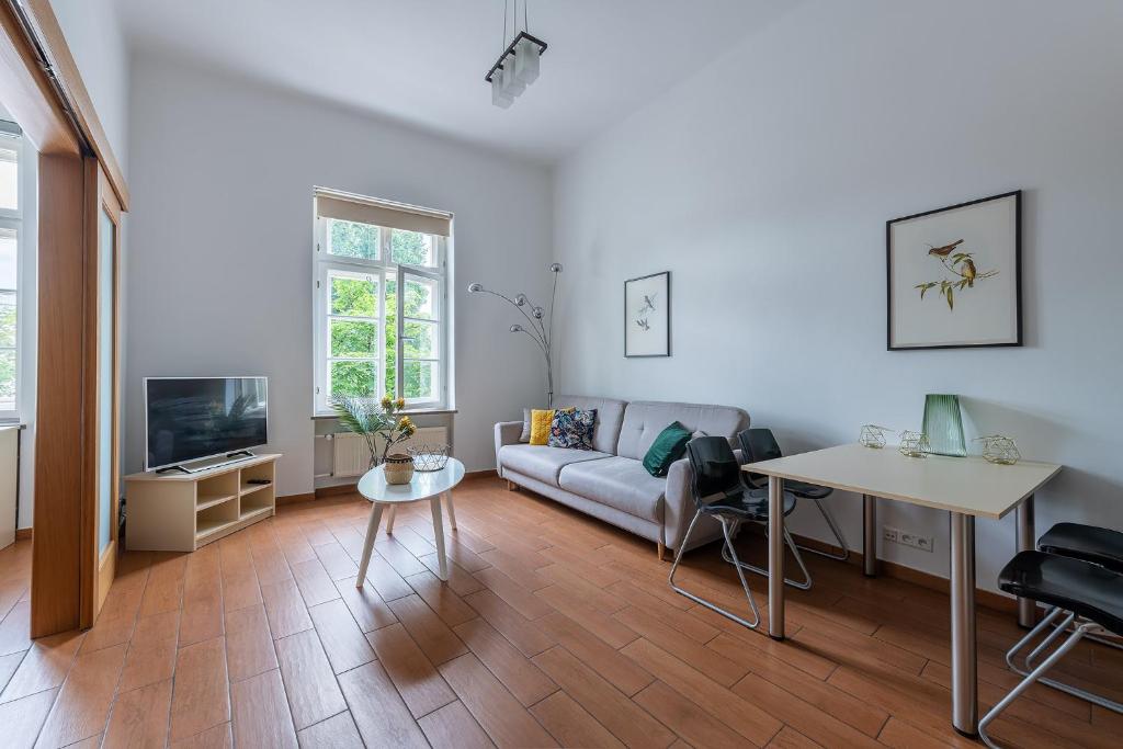 een woonkamer met een bank en een tafel bij Novis Apartments Krakowskie Przedmieście in Warschau