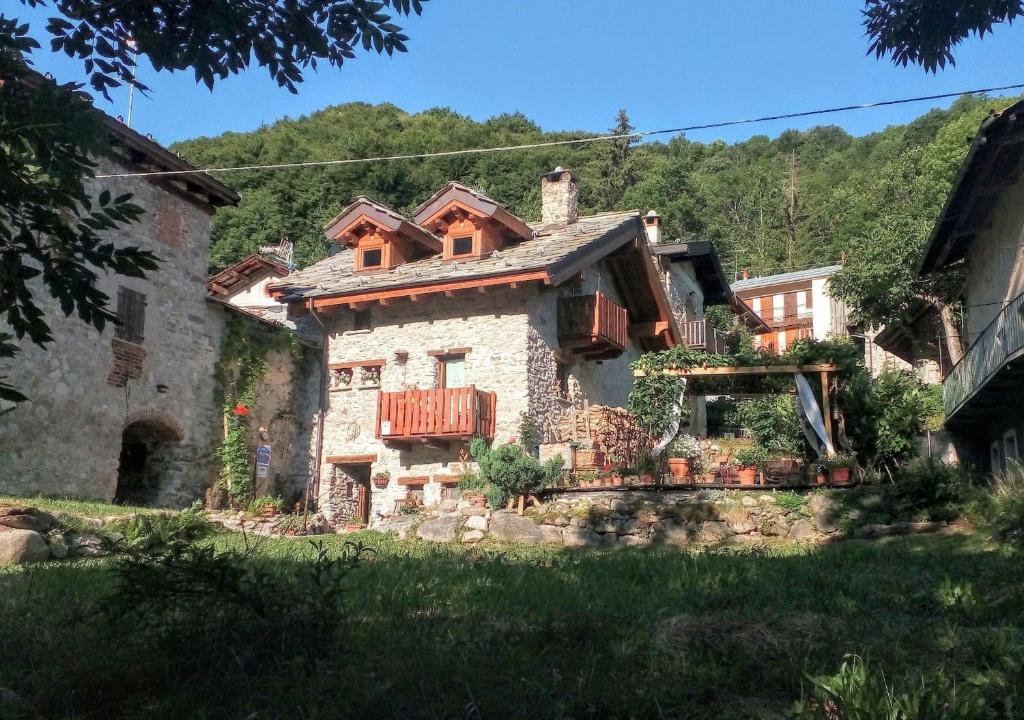 リモーネ・ピエモンテにあるB&B L'Abric - Posto Tappa GTAのポーチとバルコニー付きの古い石造りの家