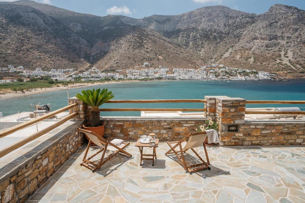 a patio with two chairs and a table and a body of water at Grand View in Kamarai