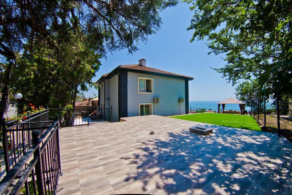 a house with a large patio and a yard at Guest house Stefan in Balchik