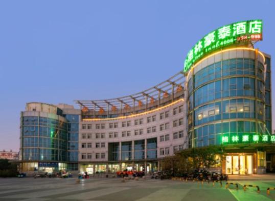 a large building with green lights on top of it at GreenTree Inn Jiangsu Suzhou Shengze Bus Station Business Hotel in Suzhou