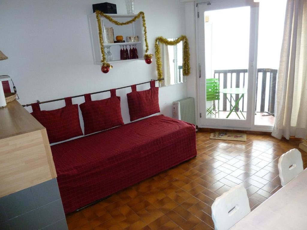 a living room with a red couch and a large window at Gentiane in Les Orres