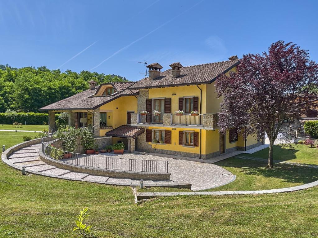 une grande maison jaune avec une grande cour dans l'établissement Villa Giulia, à Gragnola
