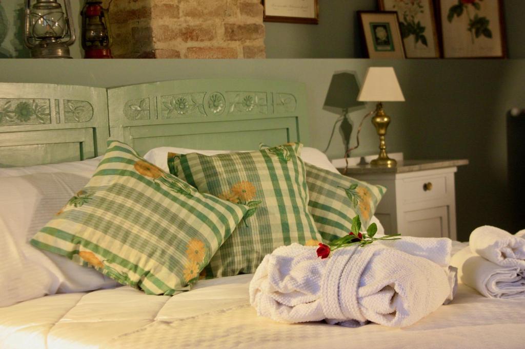 Una cama blanca con almohadas y toallas. en Casapaletti Country House, en Alfiano Natta