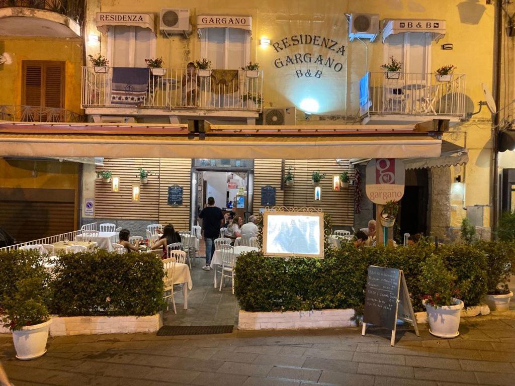 un ristorante con persone sedute fuori da un edificio di Residenza Gargano a Tropea