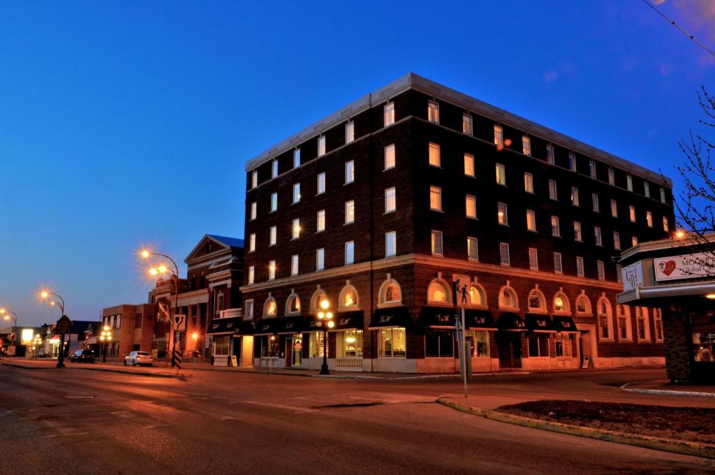 a building on the corner of a street at night at Grant Hall Hotel in Moose Jaw