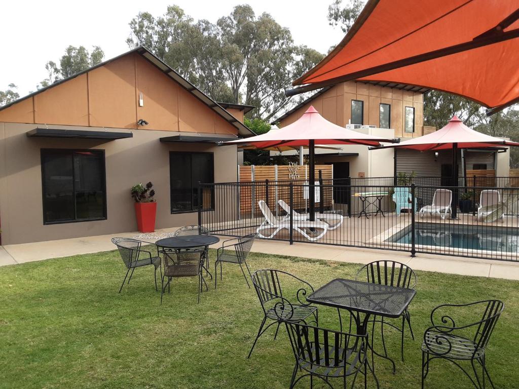 a group of tables and chairs in front of a building at Adelphi Apartment 2- Poolside or Apartment 2A- King Studio in Echuca