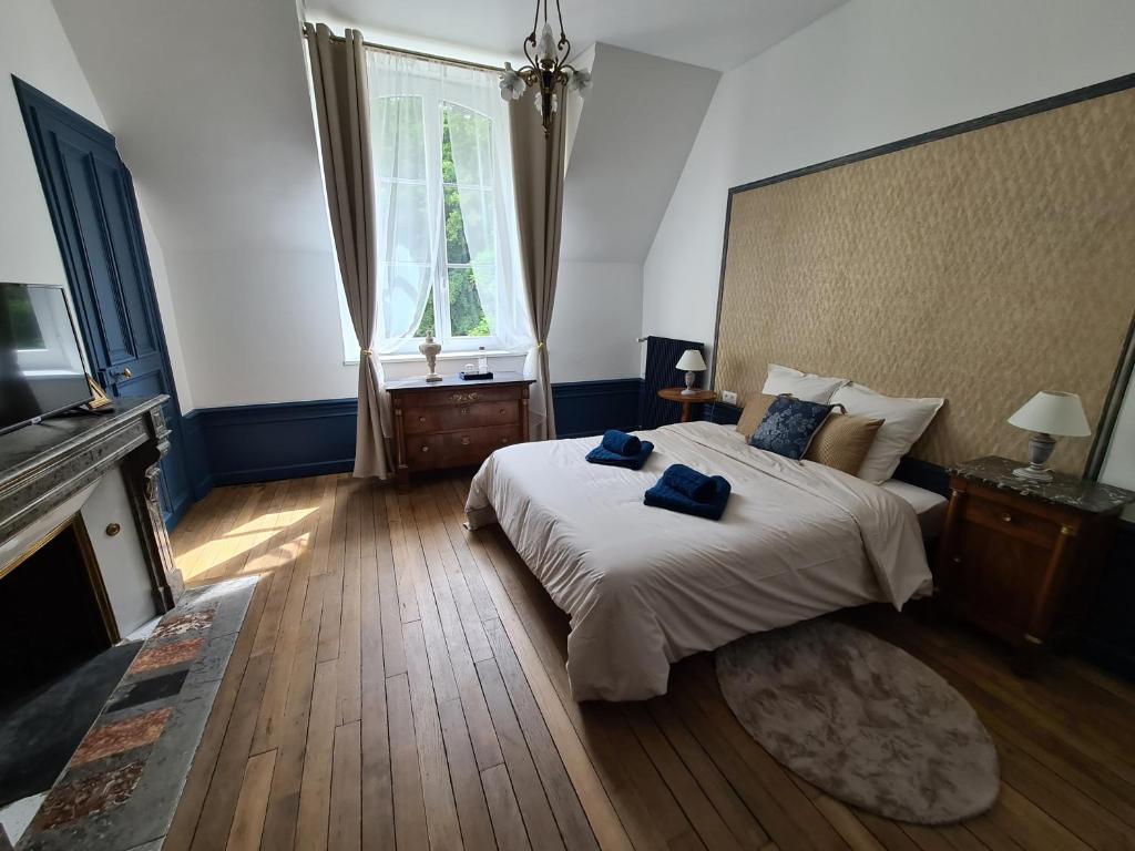 Un dormitorio con una cama con dos toallas azules encima. en Maison d'hôtes Au Cœur des Lacs, en Lusigny-sur-Barse