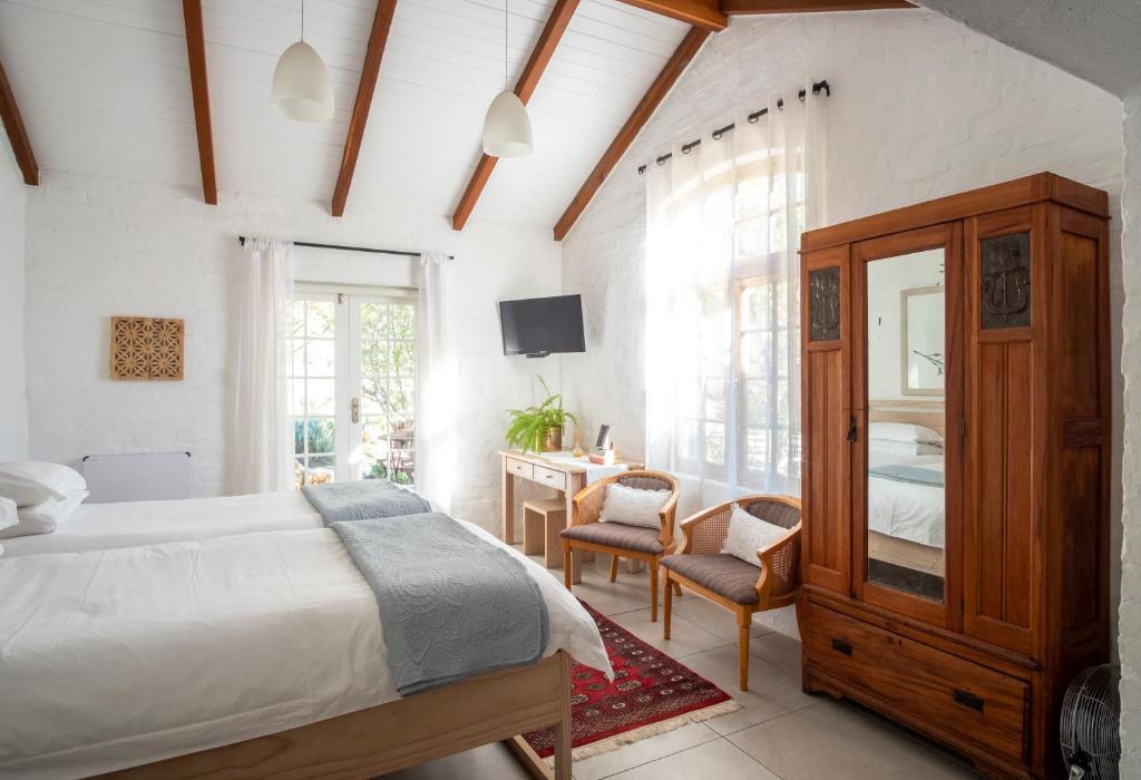 a bedroom with a bed and a desk and a television at Kogman & Keisie Guest Farm in Montagu
