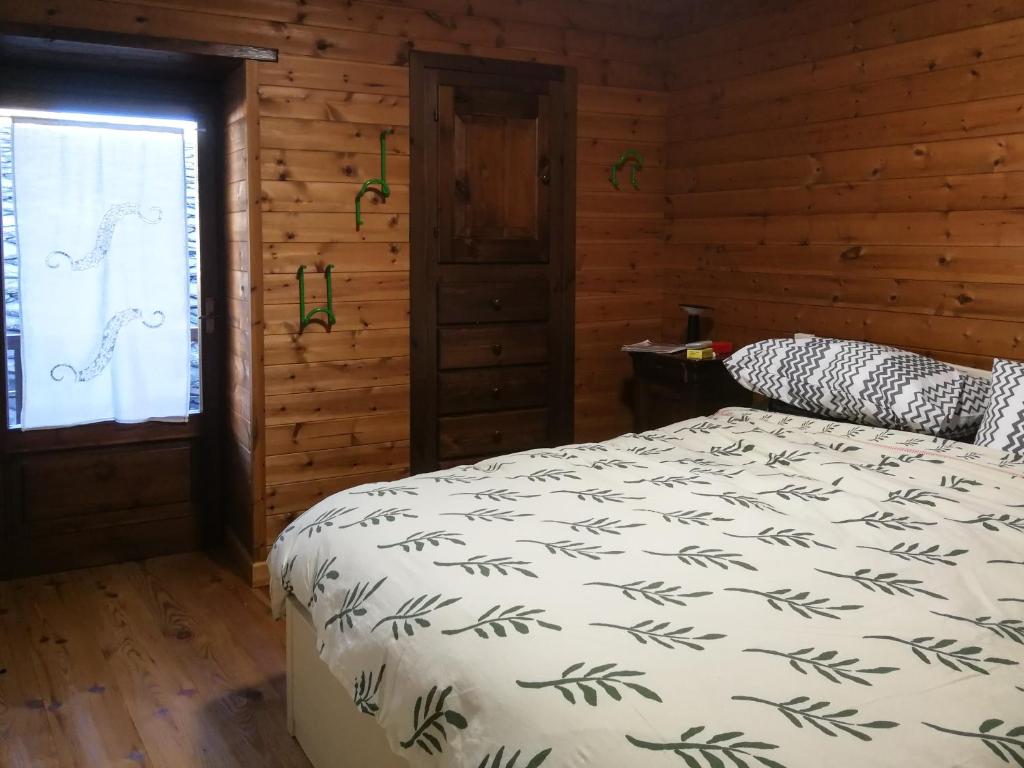 una camera con un letto in una baita di tronchi di Casa Nossur a La Salle