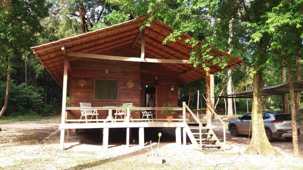 eine kleine Hütte mit einer Veranda, einem Tisch und Stühlen in der Unterkunft Chalé Juquiri in Santarém