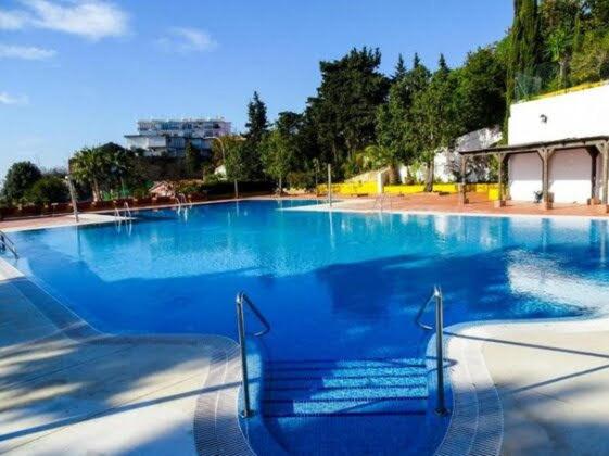 uma grande piscina com água azul em Apartment Armenka Duquesa em Torremolinos