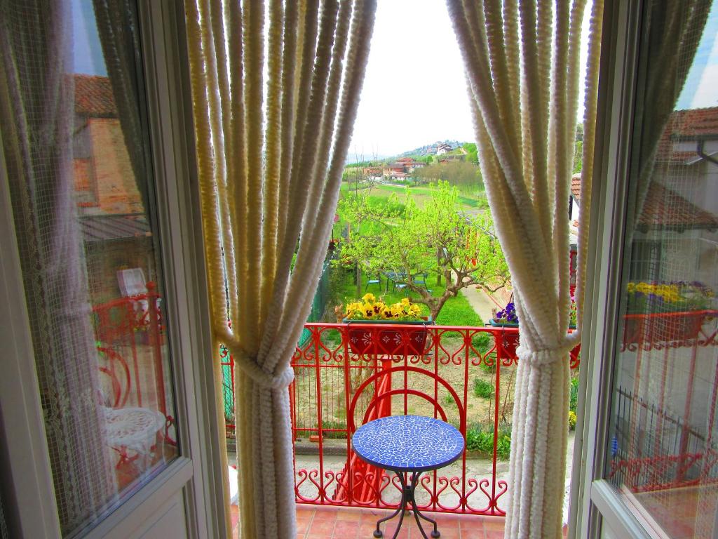 uma vista para uma varanda com uma mesa e uma janela em Villetta Sampaguita em Govone