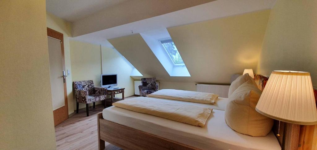 1 dormitorio con 1 cama con lámpara y escritorio en Hotel Schatthaus en Greetsiel