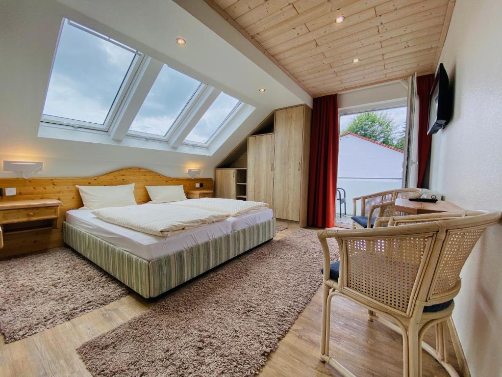 Landhotel Edersee في فالديك: غرفة نوم بسرير ومكتب وكرسي