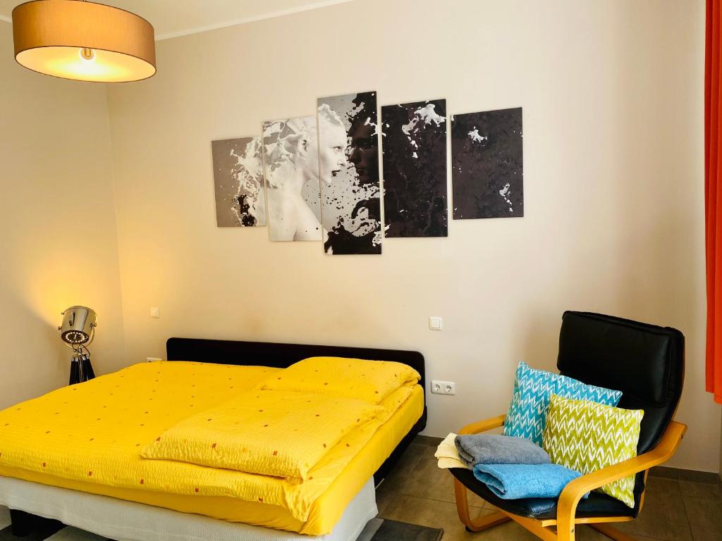 ein Schlafzimmer mit einem gelben Bett und einem Stuhl in der Unterkunft Villa FeWo mit separaten Schlafmöglichkeiten, zentral gelegen in Chemnitz