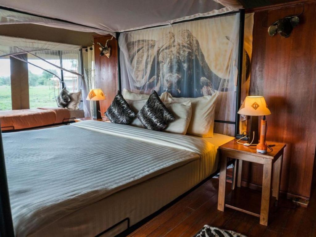 a bedroom with a canopy bed with pillows at Serengeti Sound of Silence in Serengeti National Park