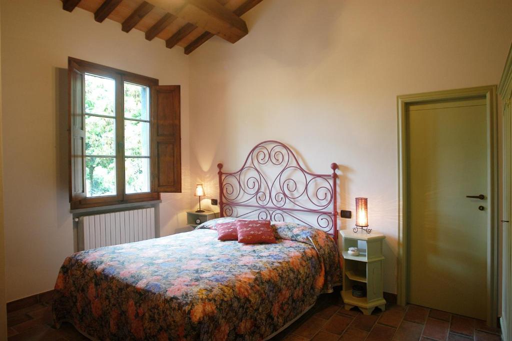 ein Schlafzimmer mit einem großen Bett und einem Fenster in der Unterkunft Agriturismo Villino del Grillo in San Gimignano