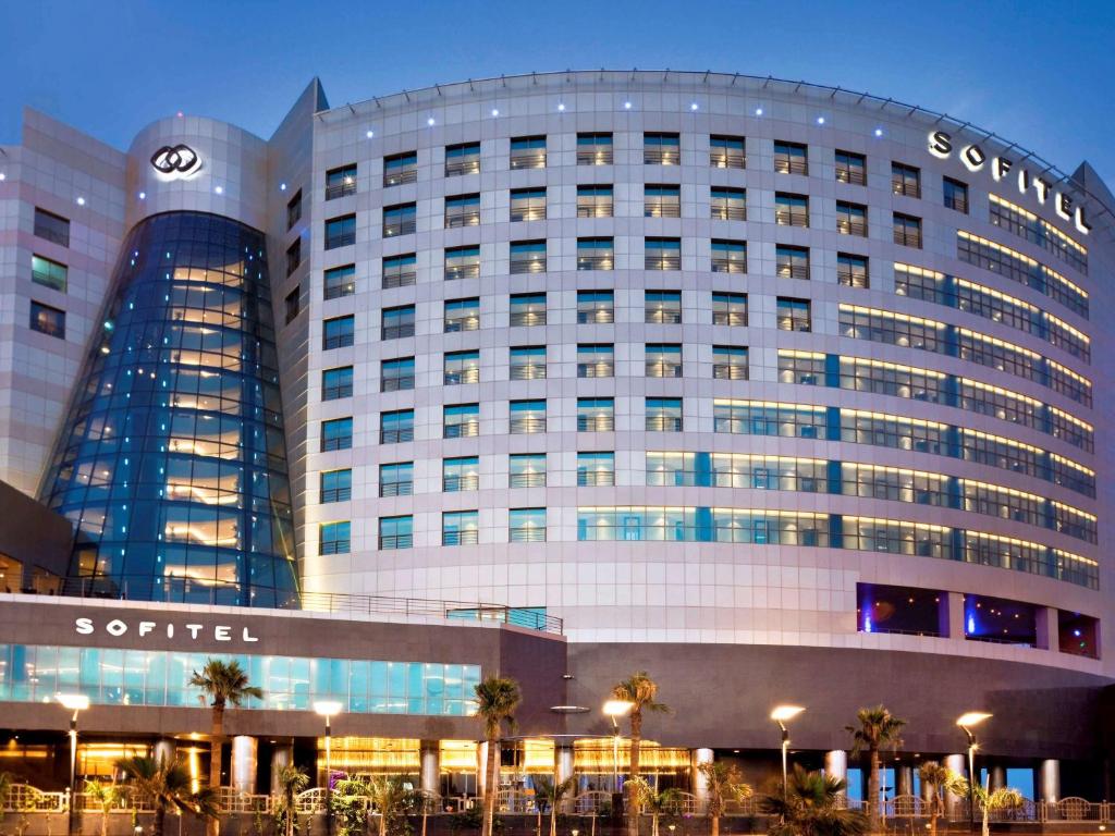 a large building with a clock on the side of it at Sofitel Al Khobar The Corniche in Al Khobar