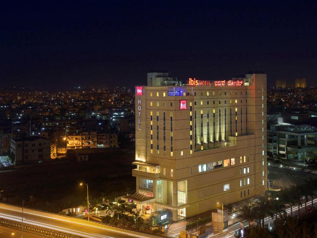 um edifício alto com luzes em cima à noite em ibis Bengaluru Hosur Road - An Accor Brand em Bangalore