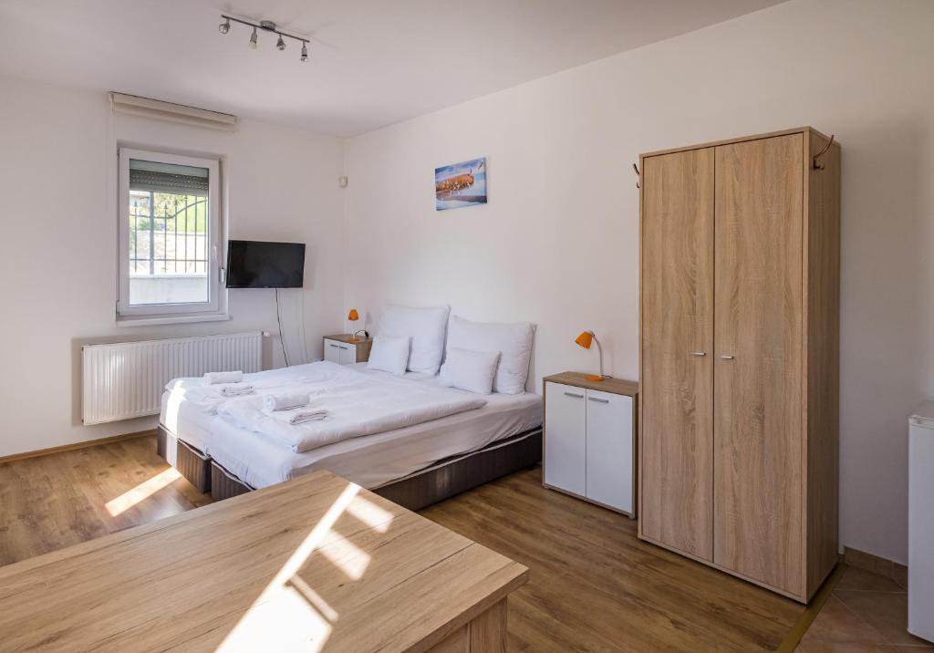 Schlafzimmer mit einem Bett und einem Holzschrank in der Unterkunft Bordoma Falusi Vendégház in Balatonszőlős