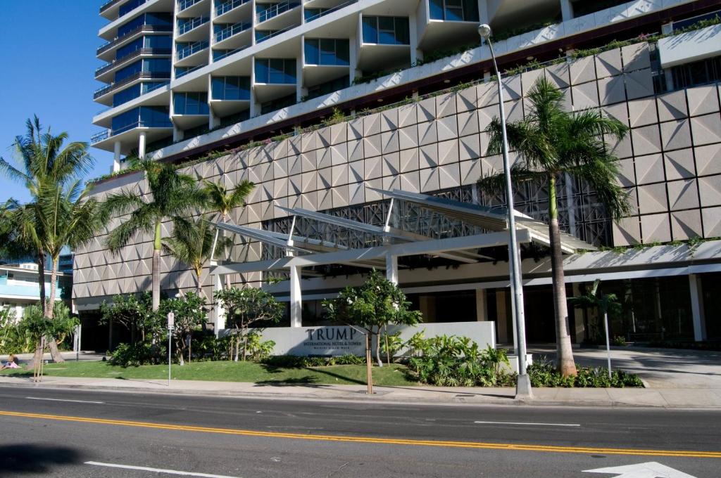 a building with palm trees in front of a street at Jet Luxury Private Residences in Waikiki in Honolulu