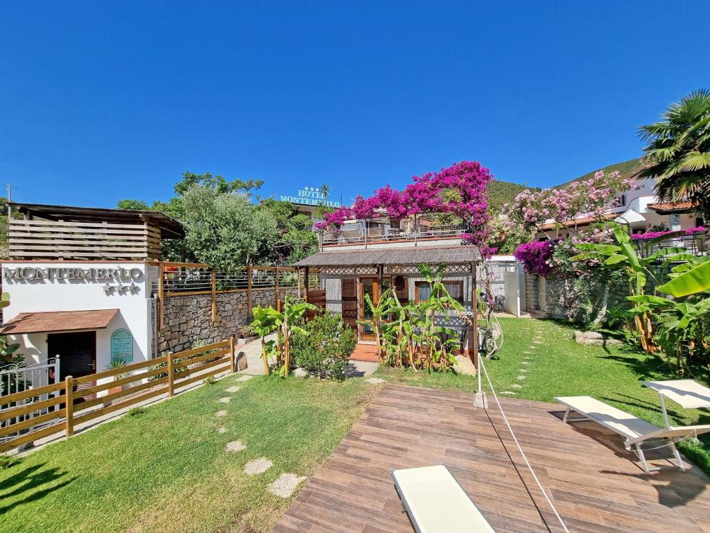a backyard of a house with a wooden deck at Eco Hotel Montemerlo in Fetovaia