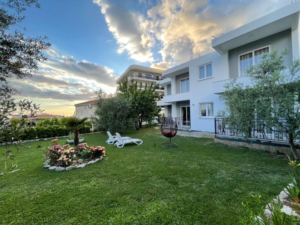 a view of a yard with a white building at Sea Garden Apartments in Dobra Voda