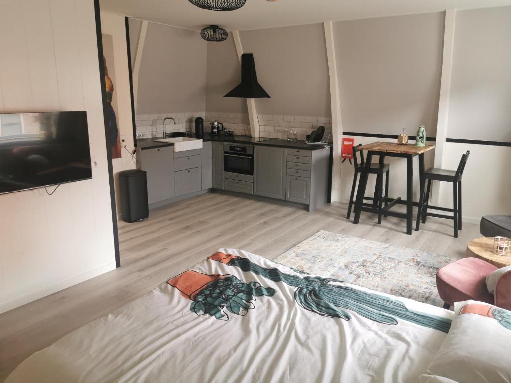 een woonkamer met een bank en een keuken bij B&B Tasty in Sneek