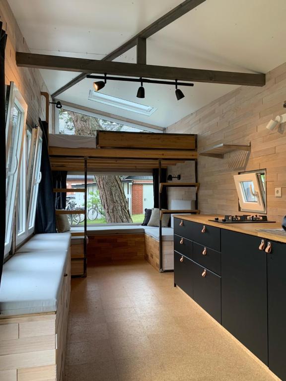 a kitchen with black cabinets and a large window at Tiny House by Lieblingsplatz in Sankt Peter-Ording