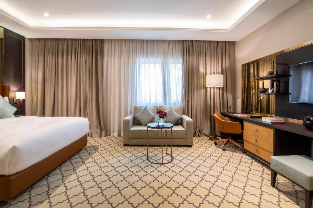 a hotel room with a bed and a desk at Gardino Hotel & Residence in Riyadh