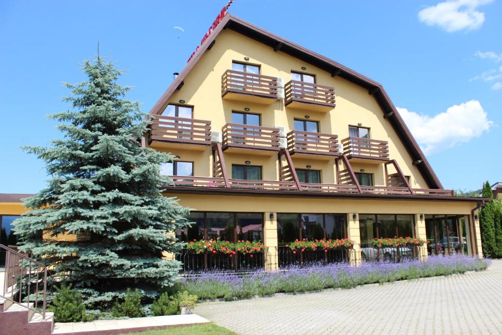 a building with a christmas tree in front of it at Vila Trapez in Braşov