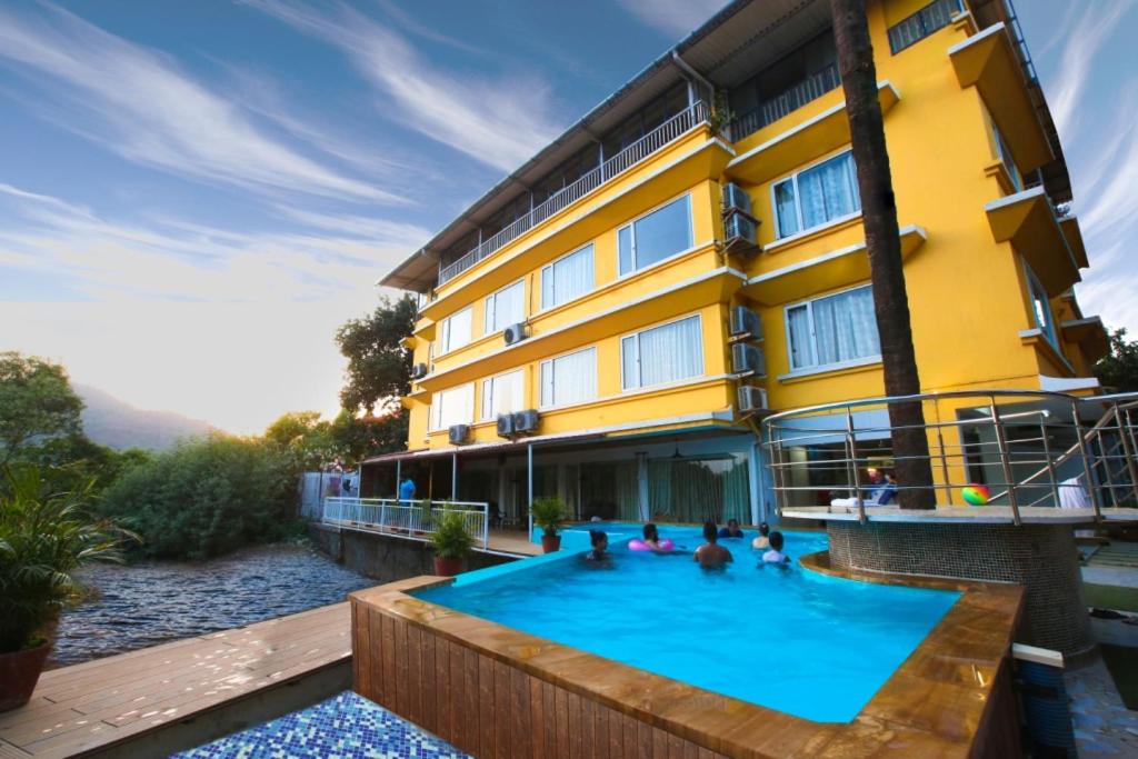 a hotel with a swimming pool in front of a building at Lake View Resort Lonavala in Lonavala