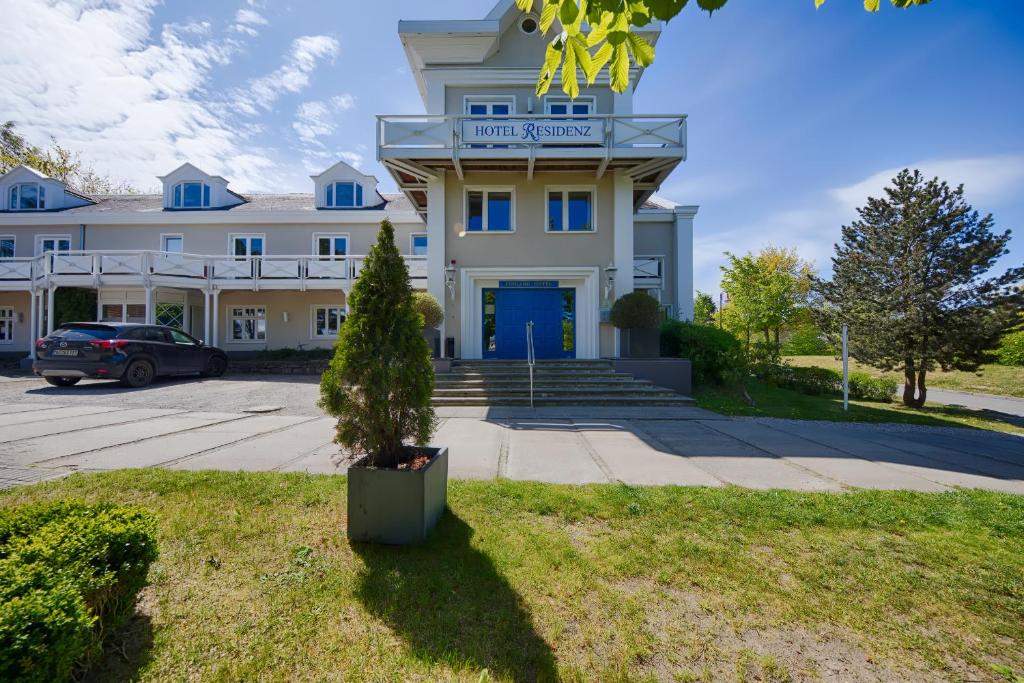 ein großes weißes Gebäude mit blauer Tür in der Unterkunft Hotel Residenz in Heringsdorf