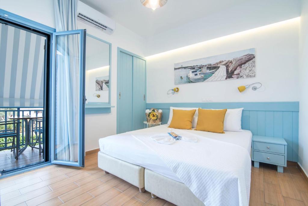 a bedroom with a bed and a balcony at Saronis Hotel Agistri - Adults Only in Skala