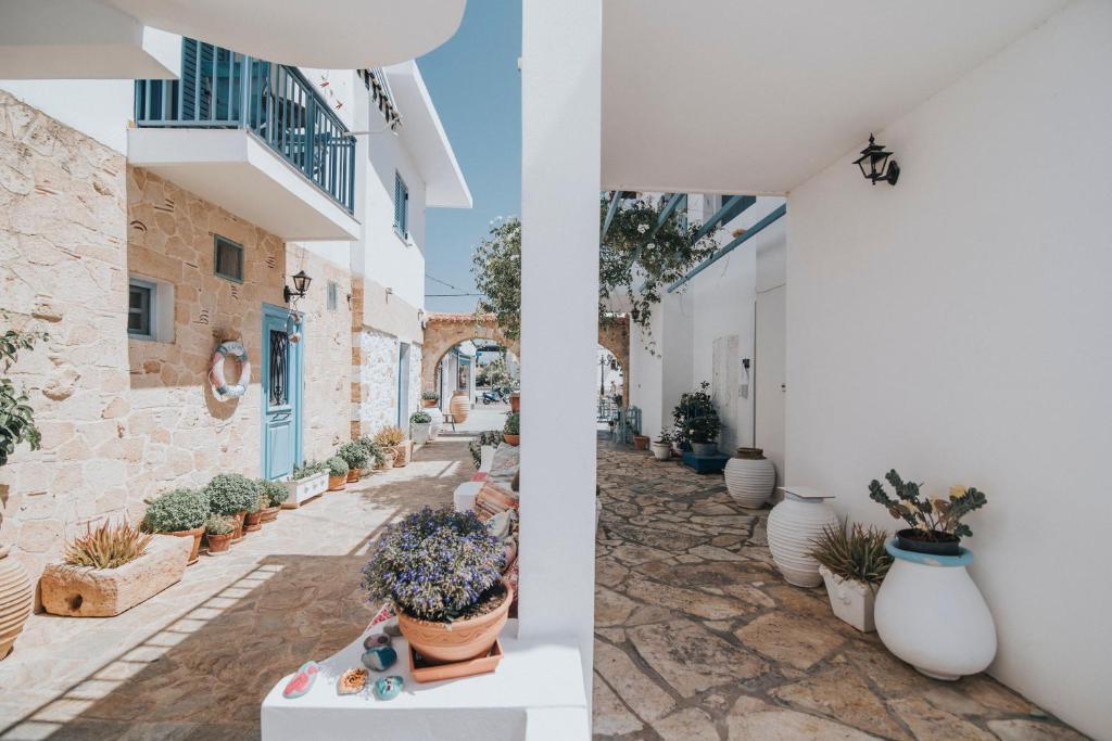 a courtyard with potted plants in a building at Saronis Hotel Agistri - Adults Only in Skala