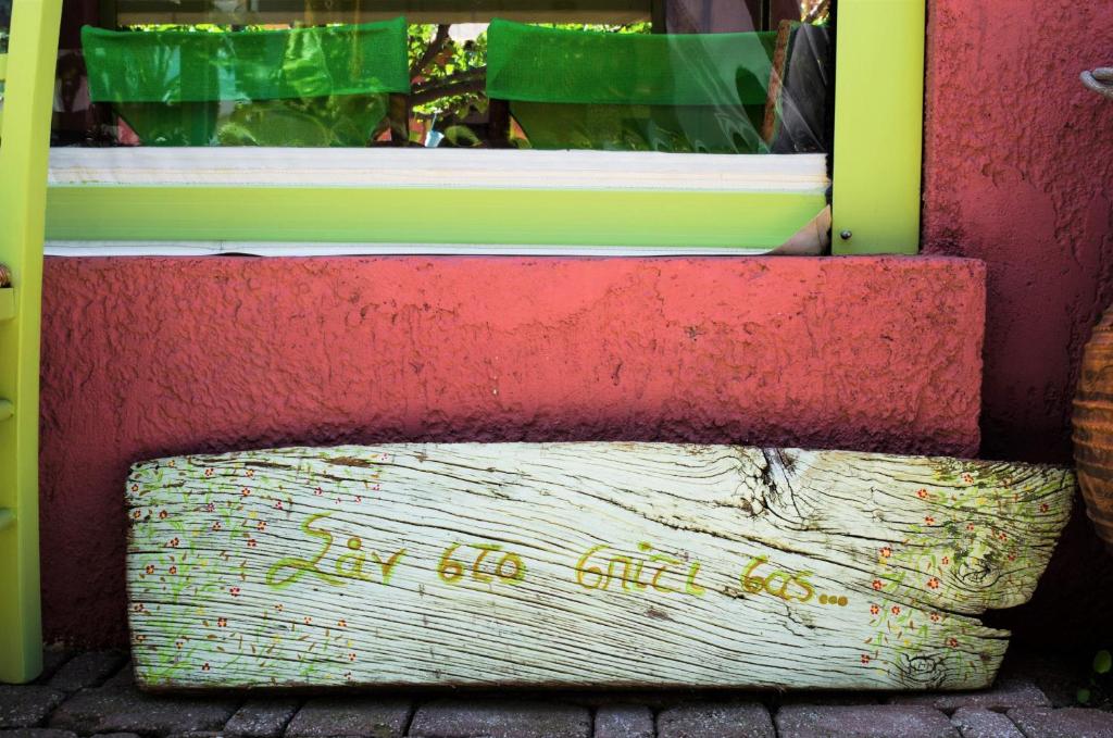 a window on a red wall with a wooden bench at Saronis Hotel Agistri - Adults Only in Skala