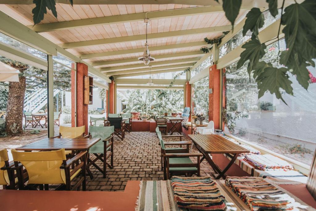 a restaurant with tables and chairs and windows at Saronis Hotel Agistri - Adults Only in Skala