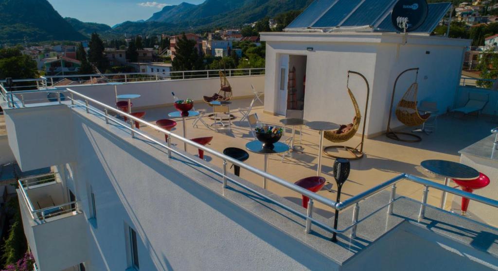 a balcony with tables and chairs on top of a building at Apartmani Nela Sutomore in Sutomore