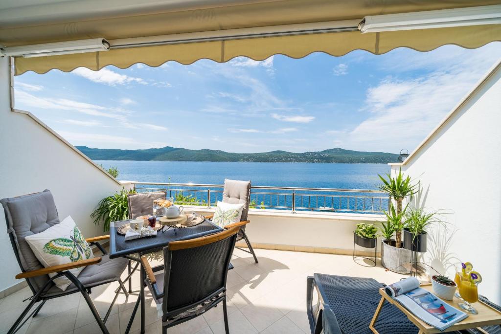 a balcony with a view of the water at Apartments Ratac Lobrović with private beach and beautiful sunset in Slano