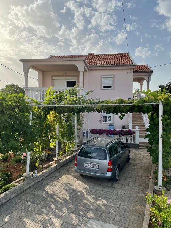 a car parked in front of a house at Apartmani Mirela in Krk