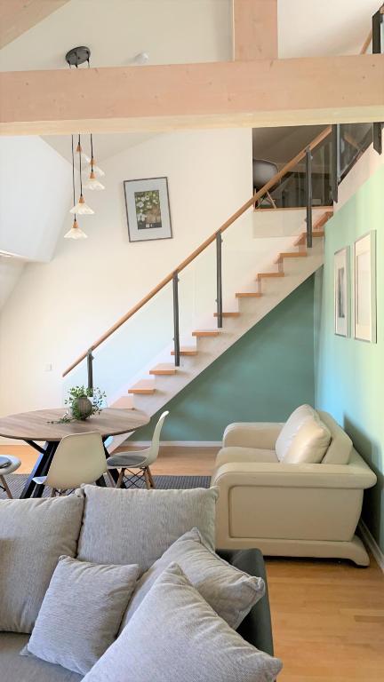 a living room with a couch and a staircase at Charming Central Apartments in Baden-Baden
