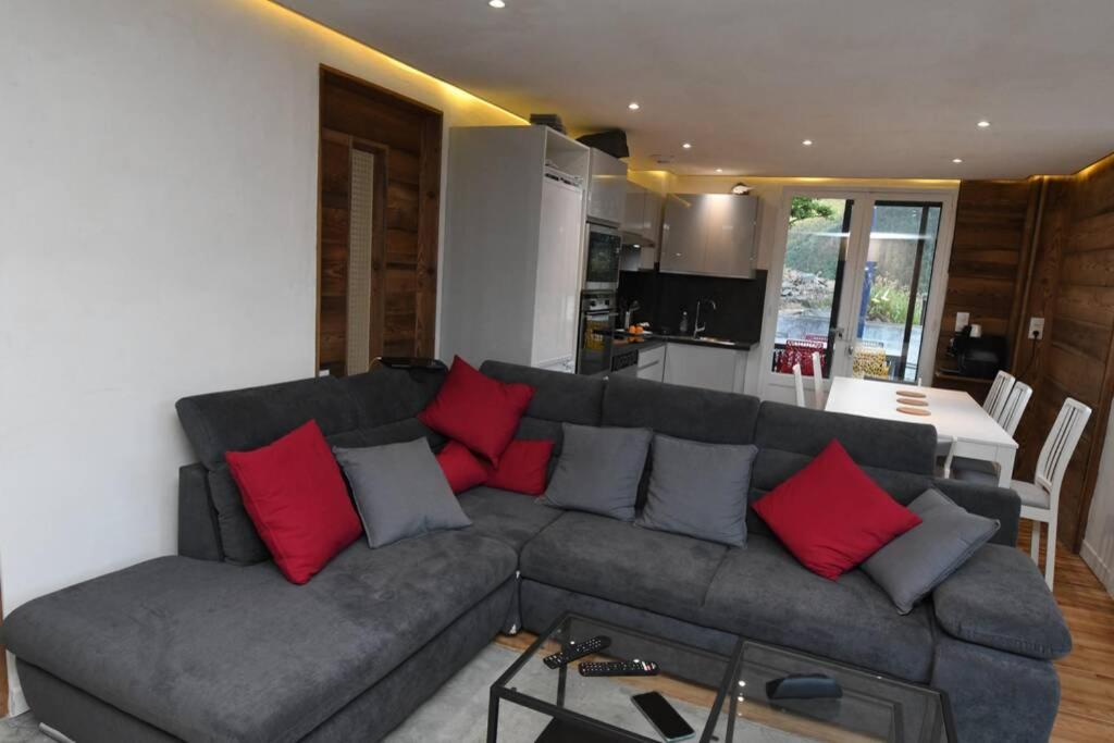 uma sala de estar com um sofá cinzento com almofadas vermelhas em Logement rénové avec vue panoramique em La Saussa