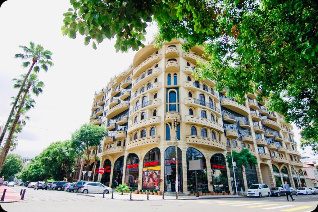 a large yellow building on the side of a street at Ekaterine's Apartments in Batumi