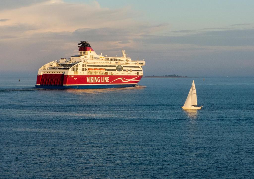 un gran barco en el agua con un pequeño velero en Viking Line ferry Viking XPRS - Night Cruise from Helsinki en Helsinki