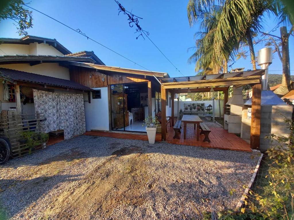 a house with a patio with a table at Loft praia Porto Belo in Porto Belo