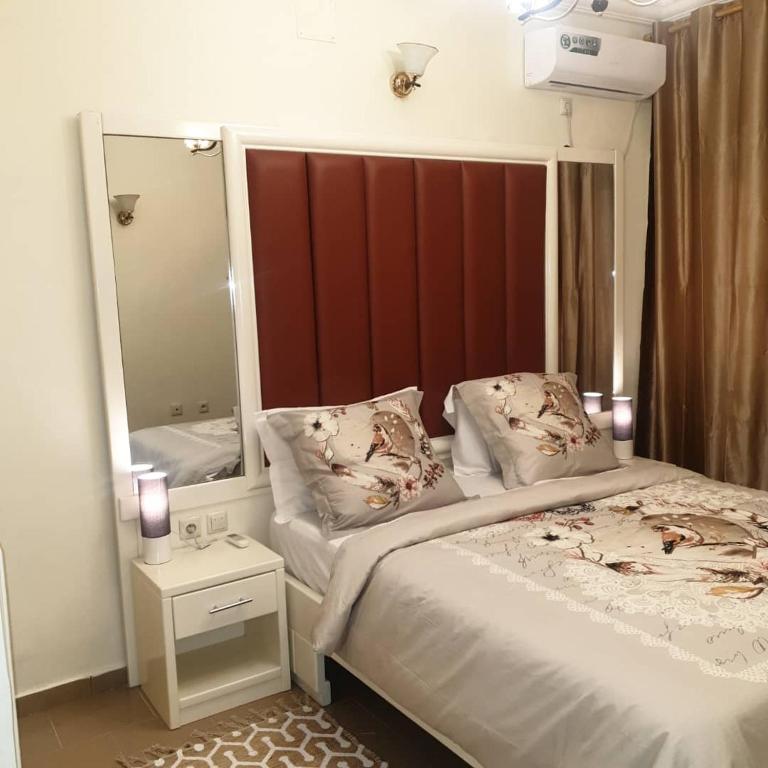 a bedroom with a bed and a large mirror at Résidence ALMA in Yaoundé