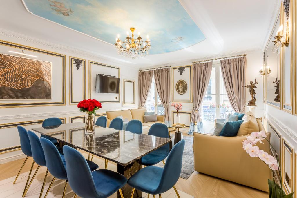 una sala da pranzo con tavolo e sedie blu di Luxury 4 Bedroom 2.5 Bathroom Apartment - Champs Elysees - With AC a Parigi