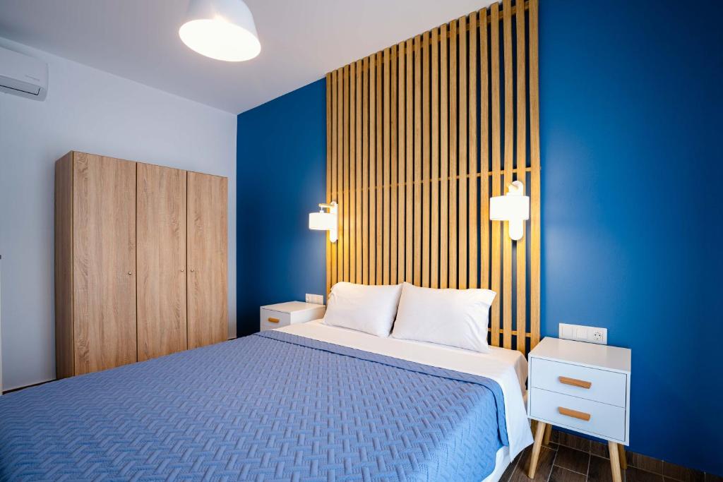 a blue bedroom with a bed and a blue wall at Elvis Nest in Nea Moudania