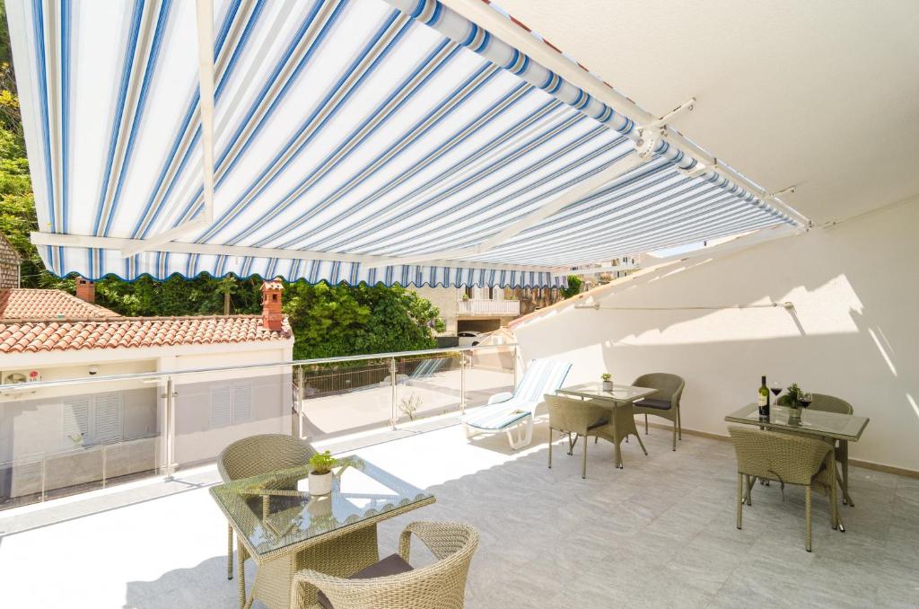 a patio with a blue and white pergola at Rooms &amp; Apartments Barišić in Mlini